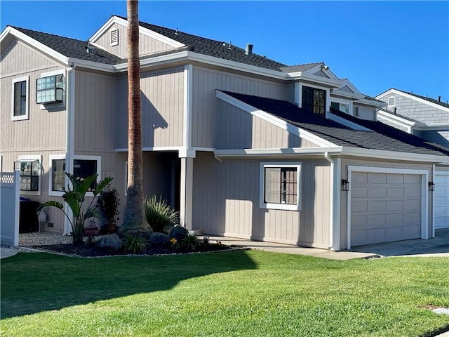 view of front of home with an attached garage, driveway, roof with shingles, and a front yard