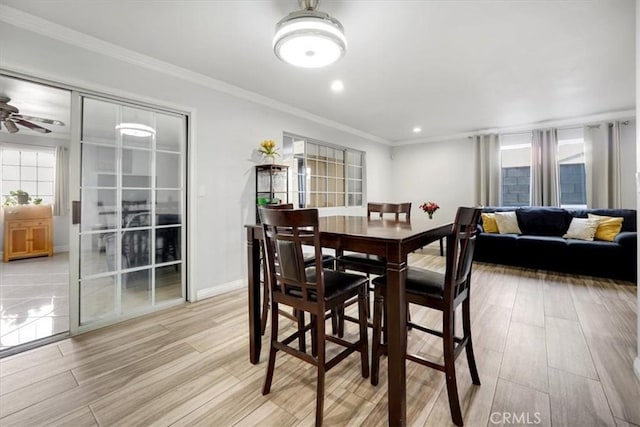 dining room featuring light wood finished floors, baseboards, a ceiling fan, crown molding, and recessed lighting