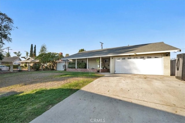 ranch-style house with a garage, concrete driveway, a front lawn, and stucco siding