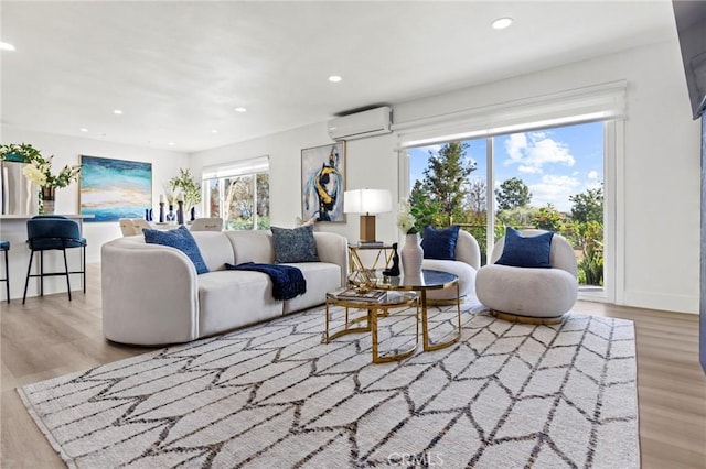 living room with recessed lighting, wood finished floors, baseboards, and a wall mounted AC