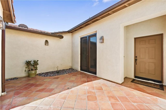 doorway to property with a patio area and stucco siding