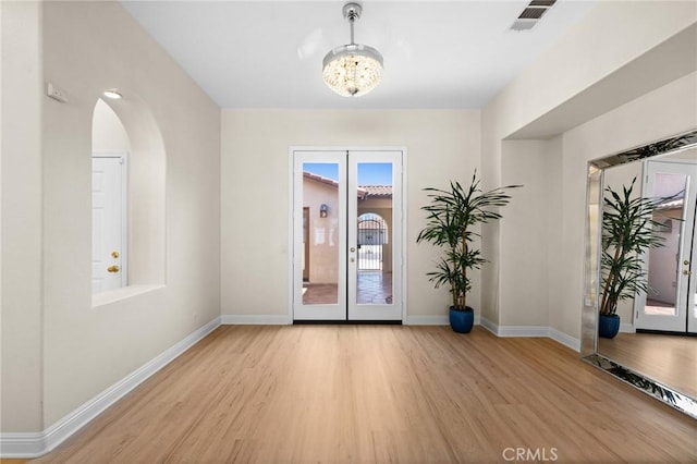 entrance foyer with light wood-type flooring, french doors, visible vents, and baseboards