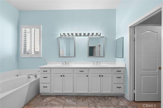 full bathroom with a bath, marble finish floor, double vanity, and a sink