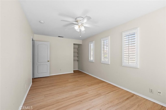 unfurnished bedroom with light wood-type flooring, baseboards, visible vents, and ceiling fan