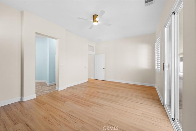 spare room featuring ceiling fan, light wood-style flooring, visible vents, and baseboards