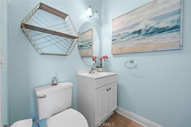 bathroom featuring vanity, wood finished floors, toilet, and baseboards