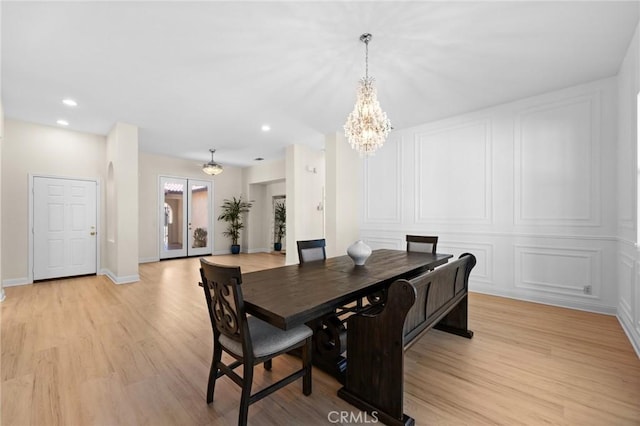 dining room with baseboards, an inviting chandelier, french doors, light wood-type flooring, and recessed lighting