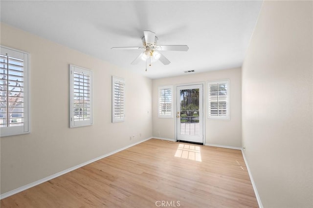 interior space featuring light wood-type flooring, ceiling fan, and baseboards