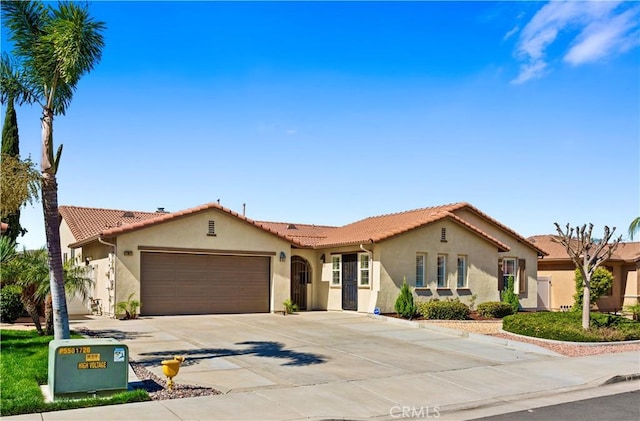 mediterranean / spanish-style house with a garage, a tile roof, driveway, and stucco siding