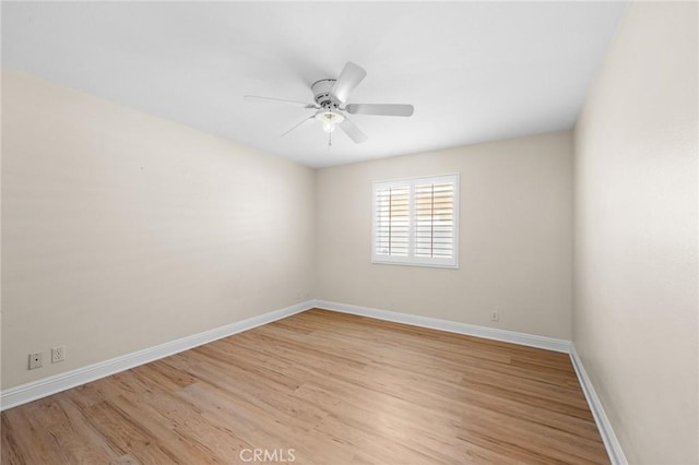 spare room featuring light wood-style flooring, baseboards, and a ceiling fan