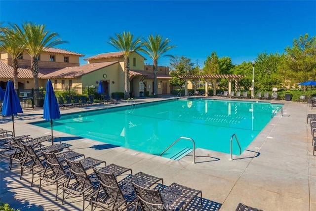 community pool featuring a patio area, fence, and a pergola