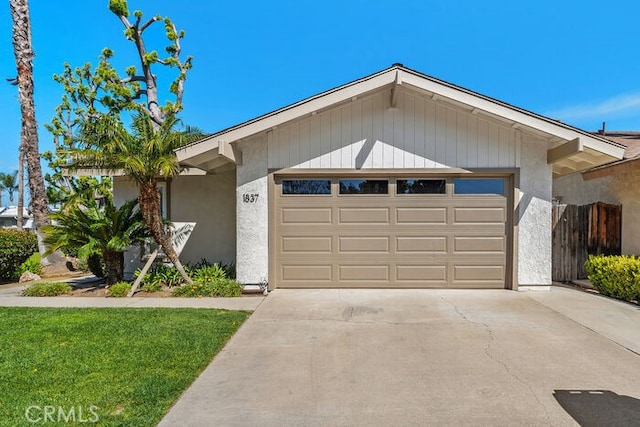 single story home featuring an attached garage, driveway, and stucco siding