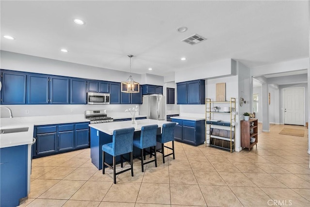 kitchen with stainless steel appliances, light countertops, visible vents, and blue cabinetry