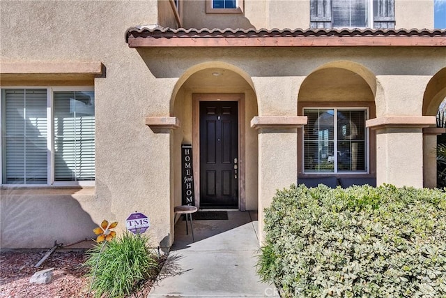 doorway to property featuring stucco siding