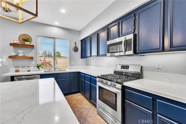 kitchen featuring light tile patterned floors, recessed lighting, a sink, blue cabinetry, and appliances with stainless steel finishes