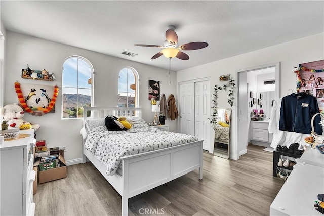 bedroom with light wood finished floors, visible vents, and baseboards