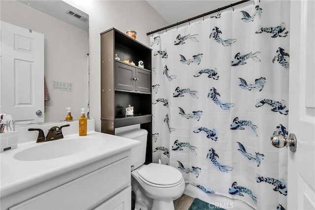 bathroom featuring toilet, visible vents, a shower with shower curtain, and vanity