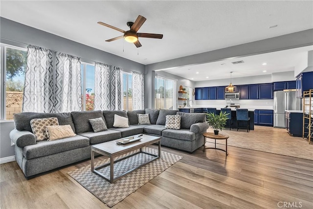 living room with recessed lighting, visible vents, ceiling fan, and light wood finished floors