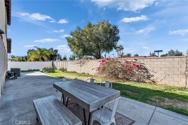 view of patio with central air condition unit, a fenced backyard, and outdoor dining space