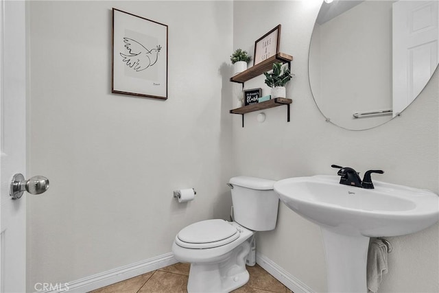 bathroom with a sink, tile patterned flooring, toilet, and baseboards