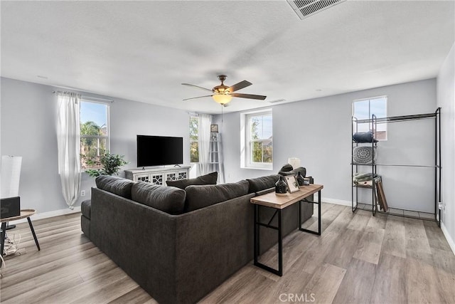 living area with light wood finished floors, baseboards, and visible vents