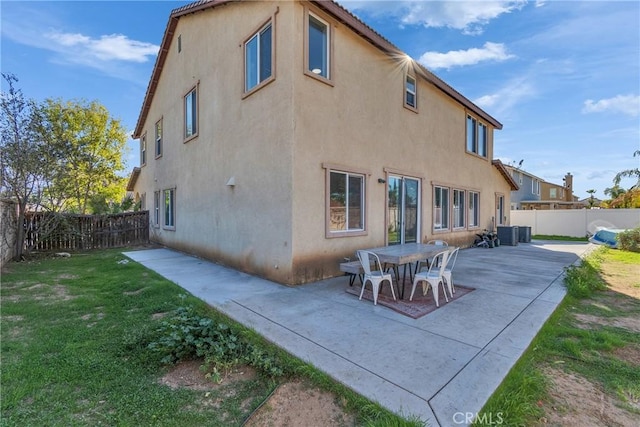 back of property with a lawn, a patio area, a fenced backyard, and stucco siding