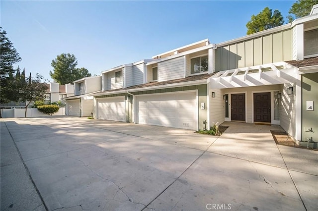 multi unit property featuring a garage, driveway, and board and batten siding