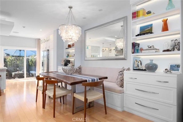 dining space featuring built in features, breakfast area, light wood-type flooring, recessed lighting, and a notable chandelier