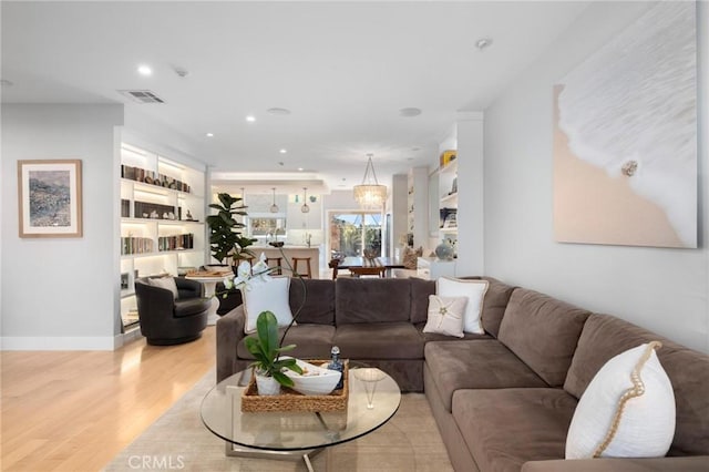 living room featuring baseboards, recessed lighting, visible vents, and light wood-type flooring