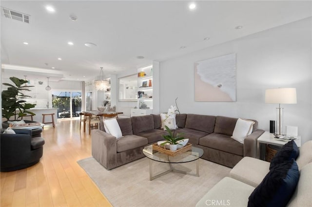 living area with light wood-style flooring, recessed lighting, and visible vents