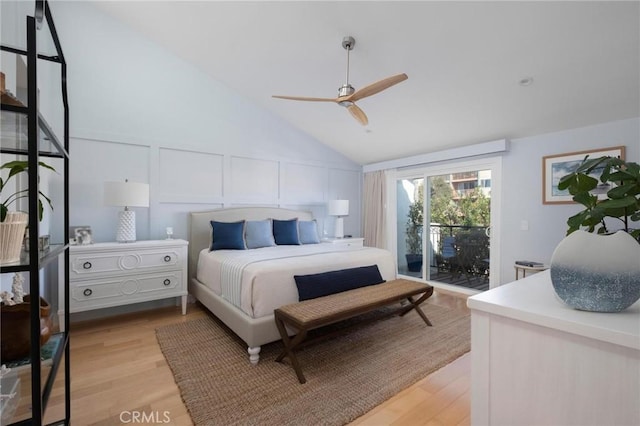 bedroom with lofted ceiling, access to outside, a decorative wall, and light wood-style flooring