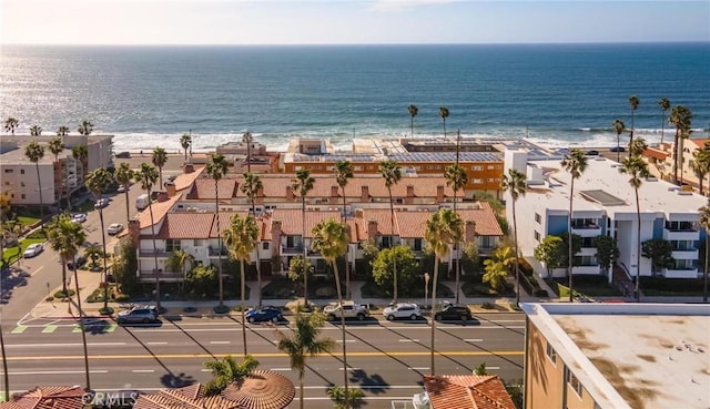 aerial view with a view of the beach, a water view, and a residential view