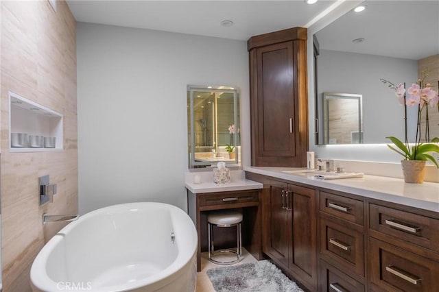 bathroom with vanity and a freestanding tub