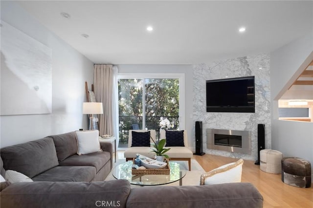 living room featuring recessed lighting, wood finished floors, and a fireplace