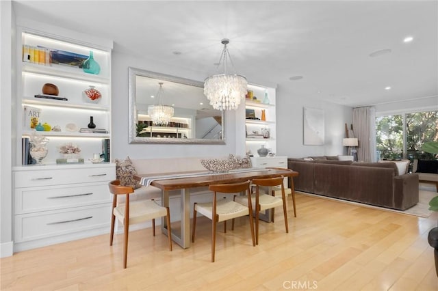 dining space featuring recessed lighting, an inviting chandelier, and light wood-style flooring