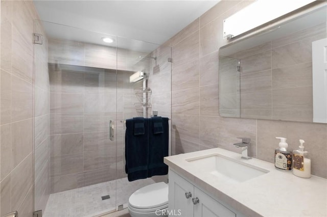 full bathroom featuring vanity, a shower stall, toilet, and tasteful backsplash