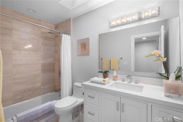 bathroom featuring tiled shower / bath combo, toilet, a skylight, and vanity