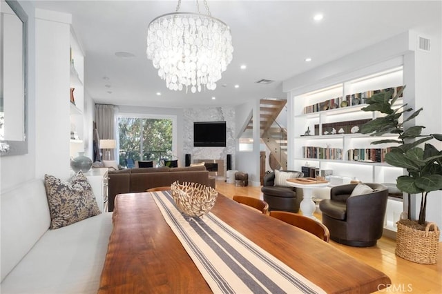 living room with visible vents, a large fireplace, a chandelier, recessed lighting, and wood finished floors