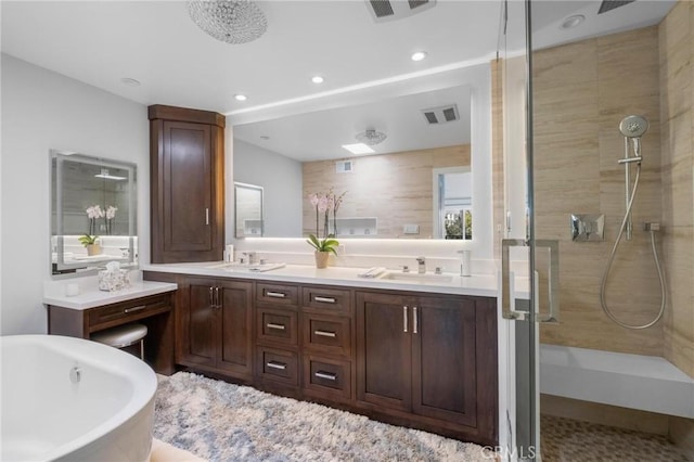 bathroom with a freestanding bath, visible vents, a stall shower, and a sink