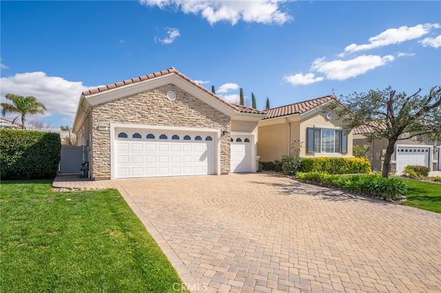 view of front facade with an attached garage, stone siding, a tiled roof, decorative driveway, and a front lawn