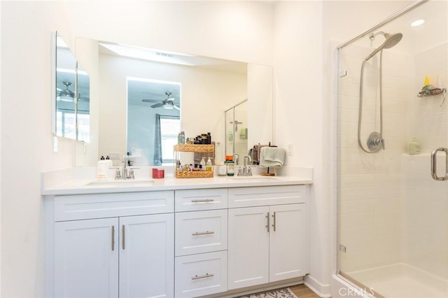 full bathroom with double vanity, a stall shower, and a sink