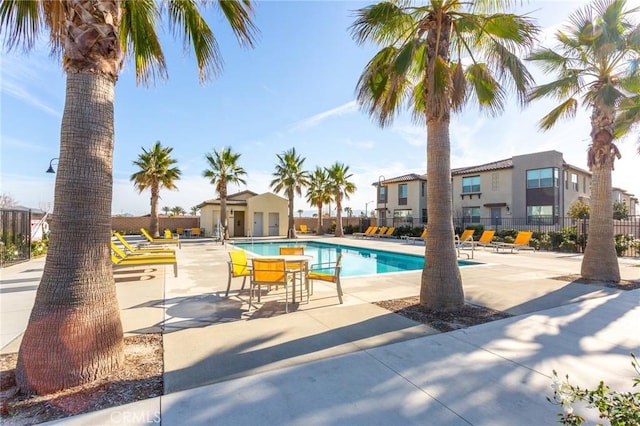 community pool with fence and a patio