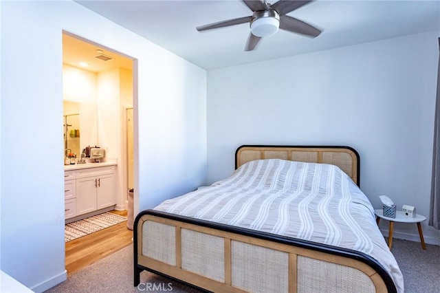 bedroom featuring baseboards, visible vents, connected bathroom, a ceiling fan, and a sink