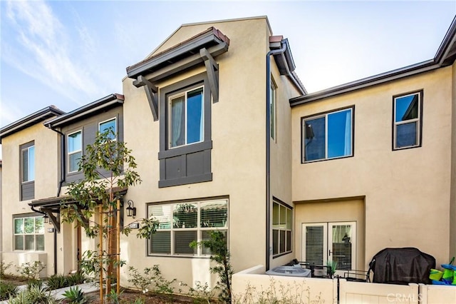 exterior space with french doors and stucco siding