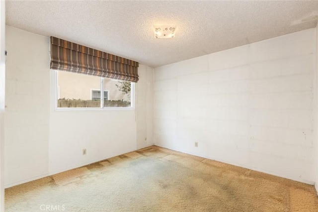 empty room featuring a textured ceiling and carpet