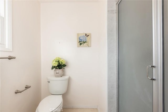 full bathroom featuring a shower stall, toilet, and baseboards