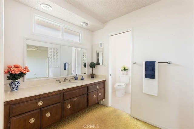 bathroom featuring toilet, a textured ceiling, and vanity