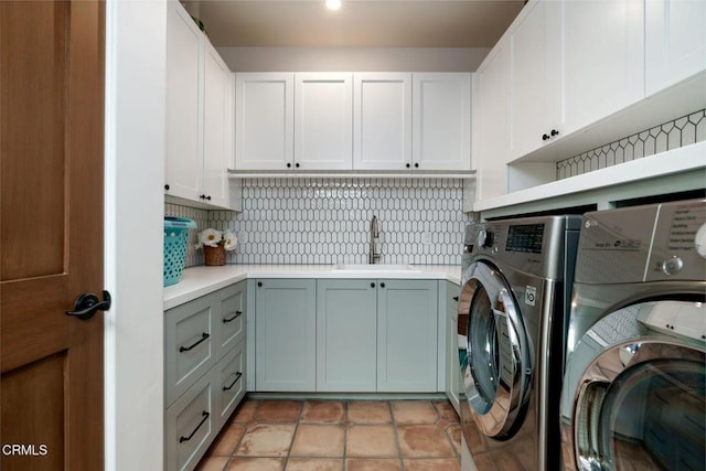 laundry room featuring a sink, light tile patterned floors, washing machine and clothes dryer, and cabinet space