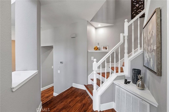 staircase with wood finished floors and baseboards