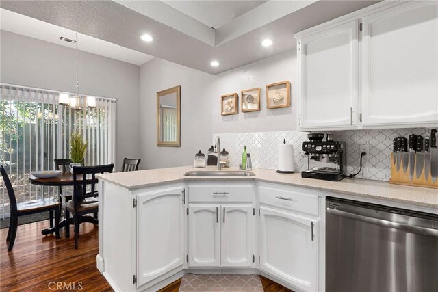 kitchen featuring a sink, a peninsula, white cabinetry, and stainless steel dishwasher